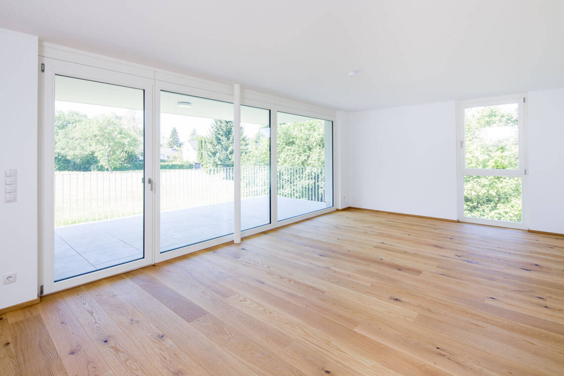 Große Holzfenster und Rahmentüren bringen viel Tageslicht in den Wohnraum der Top 4. Der Echtholzparkett schafft eine ruhige Grundlage für unterschiedliche Einrichtungskonzepte. Heller Wohnraum in Top 4