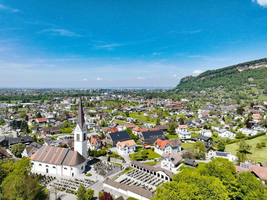 Die Vogelperspektive veranschaulicht die geplante Position der beiden Wohnhäuser am Hangfuß des Oberfeldes. Gärten, Terrassen, Wege und Grünflächen verbinden die Anlage mit der lockeren Nachbarbebauung. Luftbildvisualisierung der Wohnanlage