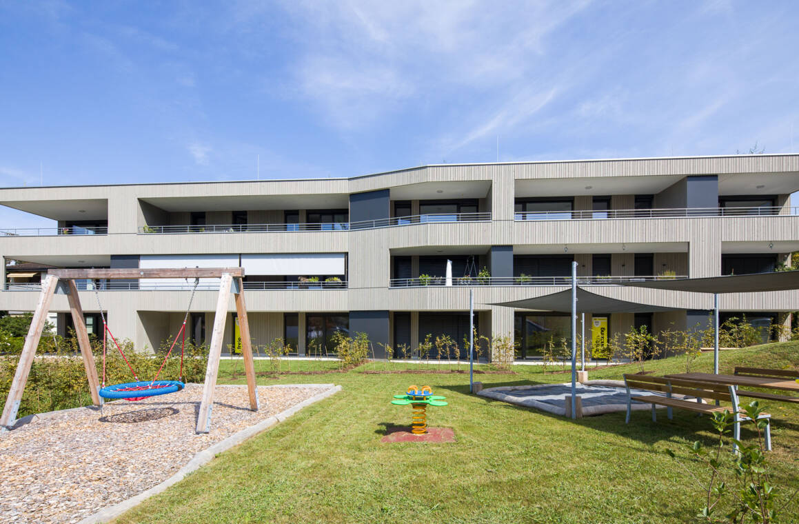 Übereinanderliegende Terrassen prägen die südliche Gebäudefassade. Im Erdgeschoss erweitern private Gartenflächen die Wohnungen ins Freie, während Hecken und Rasen die einzelnen Bereiche gliedern. Terrassen und Gärten an der Südseite © Dietmar Walser