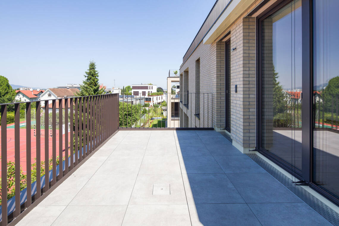 Die Terrasse mit Feinsteinzeug und Metallgeländer bietet einen offenen Außenbereich mit Blick über die Umgebung. Großzügige Terrasse mit Ausblick