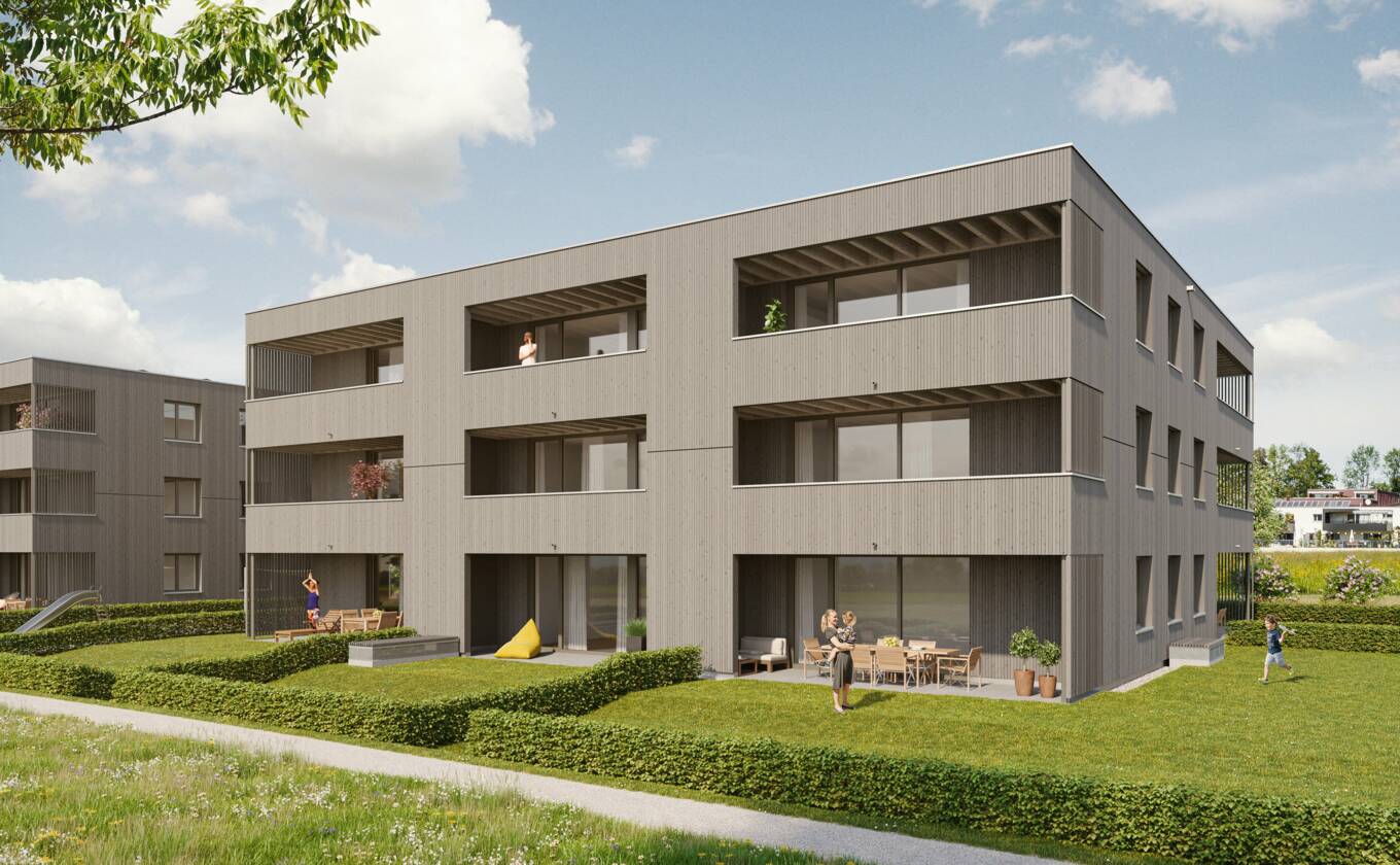 Die Architekturvisualisierung veranschaulicht das geplante Wohngebäude mit Holzfassade, großen Verglasungen, Terrassen und begrünten Außenbereichen aus südöstlicher Richtung.